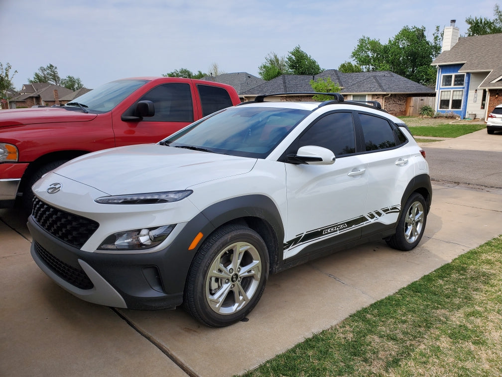 Hyundai Kona in white with black vinyl side stripe decals, parked in driveway, side profile view