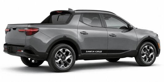 A gray compact pickup truck shown from a three-quarter rear angle on a clean white background. The vehicle has black trim along the lower body and side, silver multi-spoke wheels, and 'SANTA CRUZ' printed in white on the side panel.