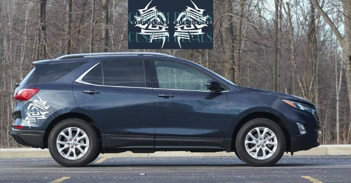 A dark blue Chevrolet SUV parked outdoors on a paved surface with bare trees in the background. A black vinyl decal sticker is shown applied to the rear left side of the vehicle, featuring a white graphic design with the text 'GREAT LAKES CUSTOM STICKERS'.