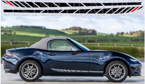A dark blue Mazda MX-5 Miata convertible with a black soft top, shown in side profile against a blurred green countryside background. A graphic decal strip is displayed at the top of the image.