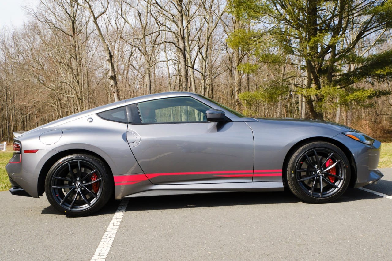 A Nissan Z car with a set of vinyl stripes decals applied on the side, parked on a road.